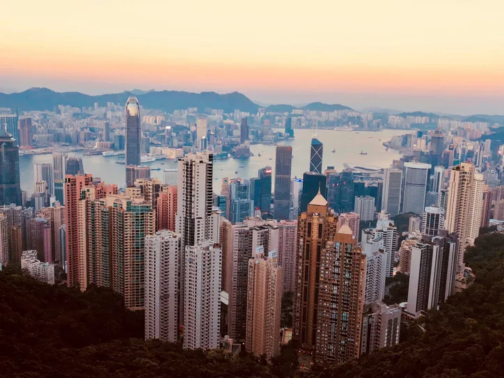 Breathtaking Kowloon skyline with skyscrapers and harbor at sunset, showcasing Hong Kong's urban beauty.