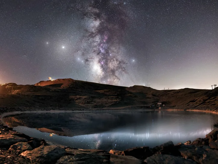 A breathtaking view of the Milky Way over a serene lake in Sierra Nevada, Spain.