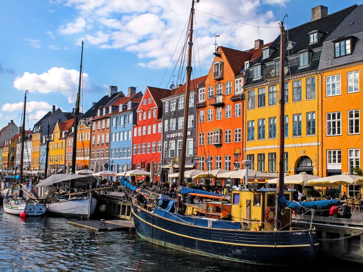 A colorful view of Nyhavn, Copenhagen's iconic waterfront with historic buildings and moored boats.