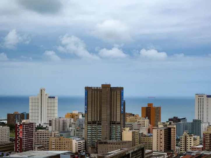 Aerial view of Durban's modern cityscape against the Indian Ocean with high-rise buildings.
