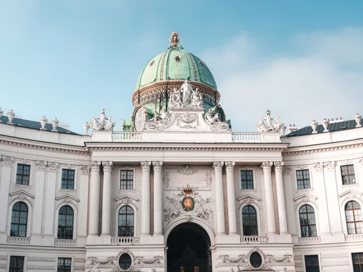 Elegant view of the Hofburg Palace's dome and facade in Vienna, Austria under a clear sky.