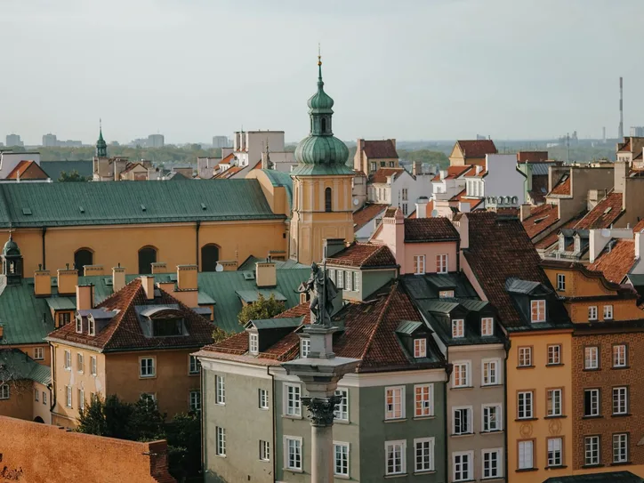Charming panoramic view of Warsaw Old Town's colorful rooftops and classic architecture under a clear sky.