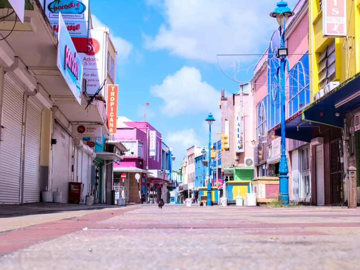 Vibrant downtown street in Bridgetown, Barbados with colorful buildings and a clear blue sky.