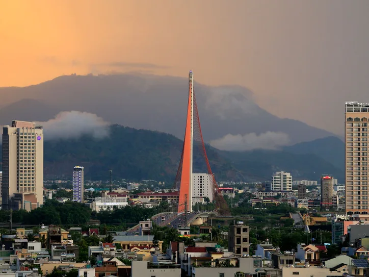 Cityscape of Da Nang featuring the iconic Han River Bridge against a sunset backdrop.