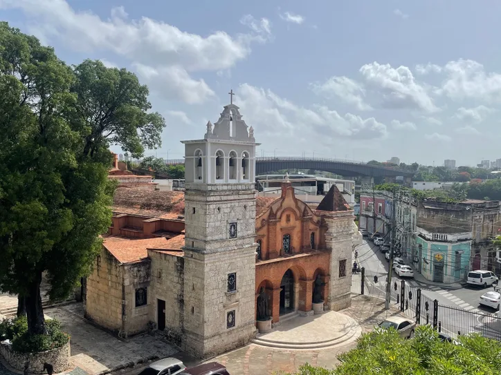 Aerial view of a historic colonial church in Santo Domingo under a bright day.