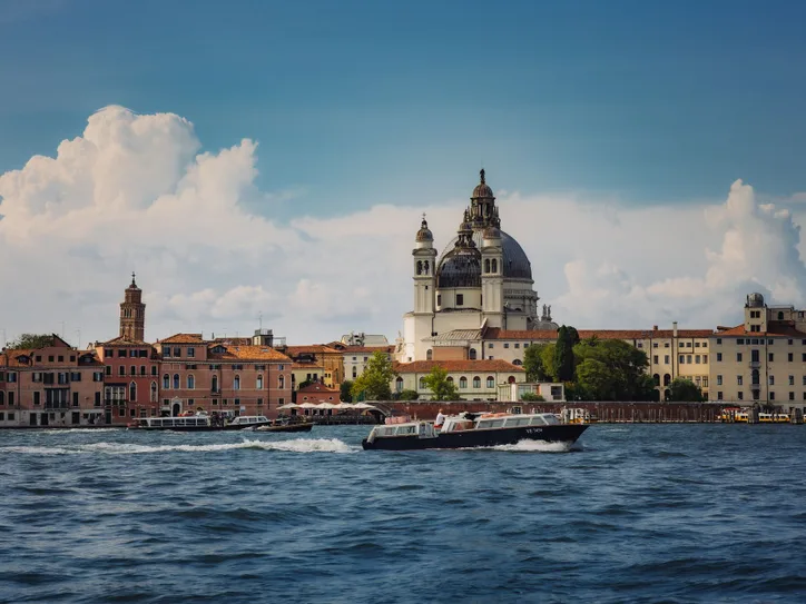 Beautiful canal view with boats and Santa Maria della Salute in Venice.