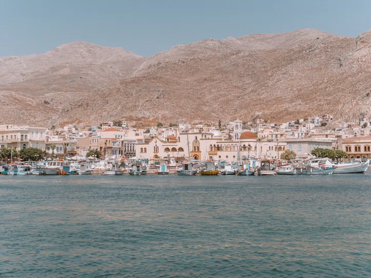 Explore the scenic beauty of Kalymnos Island's harbor with traditional architecture and calm waters.