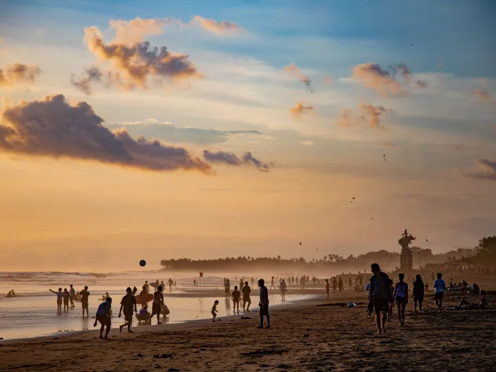 People enjoying a vibrant sunset at Canggu Beach, Bali, capturing leisure and tropical beauty.