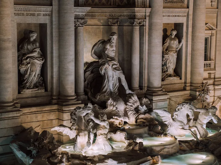 A stunning night view of the iconic Trevi Fountain in Rome, showcasing its intricate sculptures.