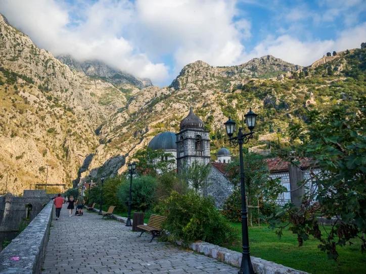 Picturesque view of Kotor's ancient pathway with mountains and historical buildings, Montenegro