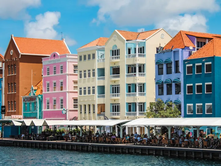 Colorful buildings line the waterfront in Willemstad, Curacao, showcasing Dutch colonial architecture.