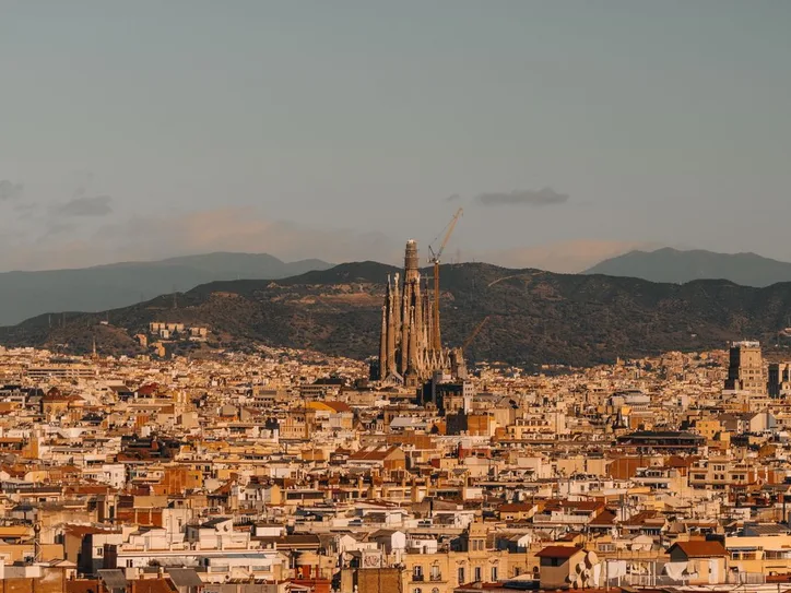 Aerial view of Barcelona with the iconic Sagrada Familia under a clear sky.