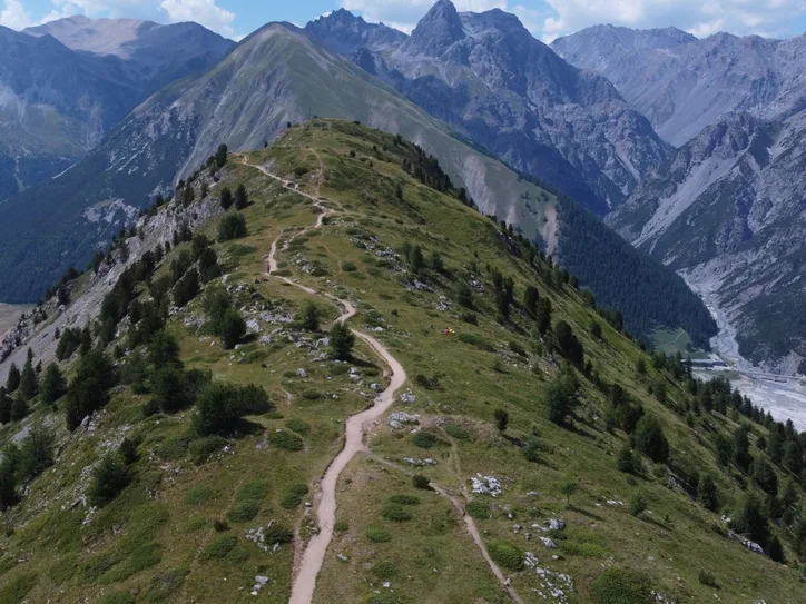 Explore stunning aerial views of Livigno's mountain trail, showcasing the serene landscape and lush greenery.