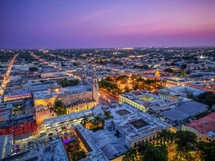 Stunning aerial panorama of Mérida, Mexico at twilight with vibrant city lights.