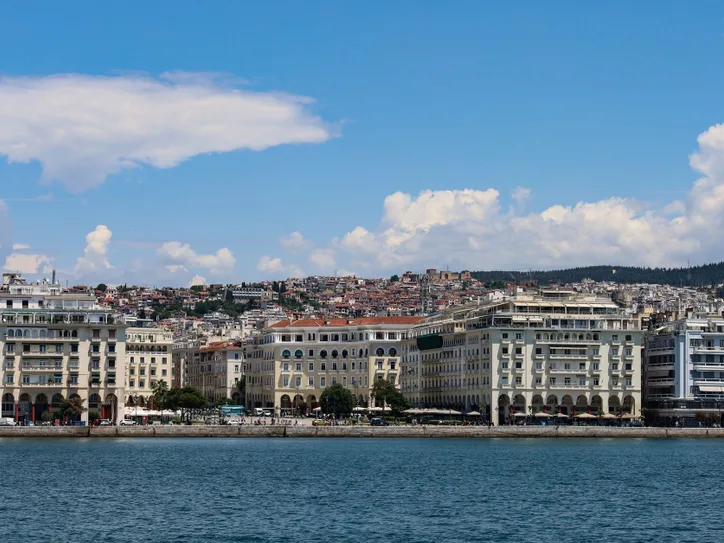 Scenic view of Thessaloniki's iconic waterfront buildings against a bright summer sky.