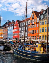 A colorful view of Nyhavn, Copenhagen's iconic waterfront with historic buildings and moored boats.